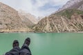 Trekkers& x27; feet by Hazor Chasma lake in Marguzor Haft Kul in Fann mountains, Tajikist