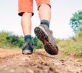 Trekking boot sole close up image traveler feet in trekking boots on mountain dirty path at summertime.Rear view shot.