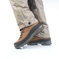 Trekking boots for hiking on the legs of a tourist on a white background. Equipment for travel and hiking