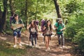 Trekking, camping and wild life concept. Four best friends are hiking in the spring woods, the guy is checking the route on a map,