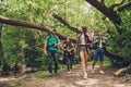 Trekking, camping and wild life concept. Two couples of friends are walking in the sunny spring woods, talking and laughing, all a Royalty Free Stock Photo