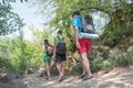 Trekking, group of hikers backpackers walking together outdoors in the forest