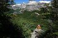 Trekking in Patagonia, Man with big backpack hiking on gray stony path in green forest with view of Jakob lagoon Royalty Free Stock Photo