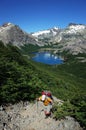 Trekking in Patagonia, Picturesque mountain lake, Man with big backpack hiking uphill on gray stony path in green forest Royalty Free Stock Photo