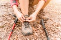 Close up of asian young woman trekking stops and sitting to tie her shoe. Royalty Free Stock Photo