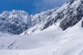 Trekking and skituring in High Tatra Mountains in winter. Trail in snow with people and the giant rocky mountains in the bacground Royalty Free Stock Photo