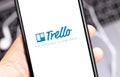 Trello logo app on the screen smartphone with blurred notebook background closeup Royalty Free Stock Photo