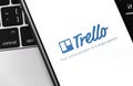 Trello logo mobile app on the screen smartphone with notebook background closeup Royalty Free Stock Photo