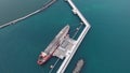 Tremendous oil tanker attached to white pier bird eye view