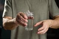 Tremor of the hands when trying to drink. Water splashes from a glass in the hand of a man with tremors, Parkinson`s disease