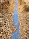 Trench with blue plastic protection tape. Marked of cables under clay during building of internet