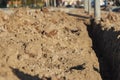 A trench in the ground prepared for laying the electrical cable at the construction site