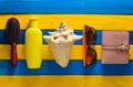 Trend accessories for relaxation on the beach and beauty on a yellow blue wooden table. Purse, comb, sunglasses, shell, sunblock Royalty Free Stock Photo