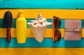 Trend accessories for relaxation on the beach and beauty on a yellow blue wooden table. Purse, comb, sunglasses, shell, sunblock. Royalty Free Stock Photo