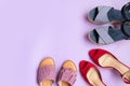 Trend beautiful bright red shoes, striped sandals and purple leather flip flops on colored background with copy space