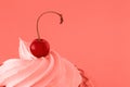 A bright ripe cherry berry on the top of a delicious cake on a pastel purple background