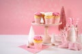 On trend pink Christmas children's party table with cupcakes and holiday decor. Royalty Free Stock Photo