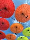 Trending colors in outdoor decor - red, yellow and soft orange umbrellas against a blue sky