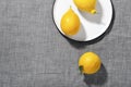 Trending colors of 2021. Yellow illuminating lemons and shadows on Ultimate gray tablecloth. Flat lay minimal still life