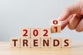 Hand flip wood cube change year 2020 to 2021 and the word TRENDS on wooden block on wood table Royalty Free Stock Photo