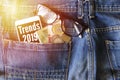 Trends 2019 inscription on phone screen / Smartphone in front jeans pocket with eye glasses and Algeria coin money.