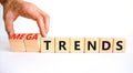 Trends or megatrends symbol. Businessman turns cubes and changes words trends to megatrends. Beautiful white table, white