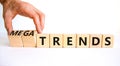 Trends or megatrends symbol. Businessman turns cubes and changes words trends to megatrends. Beautiful white table, white