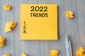 2022 Trends word on yellow note with pen and crumbled paper on wooden table background. New Year New Start, Resolutions, Strategy Royalty Free Stock Photo