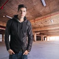 Trendy attractive young man standing in empty warehouse