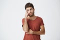 Trendy bearded young man tired of listening to somebody`s stories or reproac s. Holding his head and rolling his eyes as Royalty Free Stock Photo
