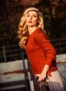 Trendy beauty. autumn woman curly hair outdoor. girl long blond hair city walk. girl in corrugated skirt and sweater Royalty Free Stock Photo