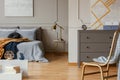 Trendy bedroom interior with grey commode