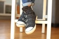 Trendy black sneakers with feet crossed.