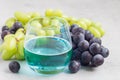 Trendy blue moscato wine in a glass, green and red grape on background, horizontal Royalty Free Stock Photo