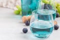 Trendy blue moscato wine in glass, green and red grape on background, horizontal Royalty Free Stock Photo