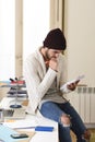 Trendy businessman in cool hipster beanie and informal look writing on pad working at home office Royalty Free Stock Photo