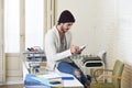 Trendy businessman in cool hipster beanie and informal look writing on pad working at home office Royalty Free Stock Photo