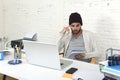 Trendy businessman in cool hipster beanie writing on pad working in at modern home office with computer Royalty Free Stock Photo