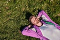 Trendy caucasian man lying in the field of green grass with copy space with his eyes closed Royalty Free Stock Photo