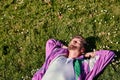 Trendy caucasian man lying in the field of green grass with copy space with his eyes closed Royalty Free Stock Photo