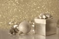Champagne colour Christmas ball, fir cone and gift box decorated with a bow on a reflective surface Royalty Free Stock Photo