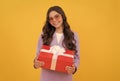 trendy cheerful child in sunglasses and suit hold present box on yellow background, birthday Royalty Free Stock Photo