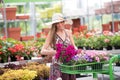 Trendy chic young woman placing flowers in a cart Royalty Free Stock Photo