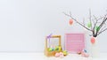 Trendy colorful composition with Easter eggs, confetti, twigs, Easter bunny. Blank photo frame for text. Easter mockup.