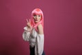 Trendy cool woman with pink hair doing peace sign and kissy face Royalty Free Stock Photo