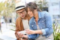 Trendy couple hanging in town using smartphone