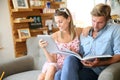 Trendy couple reading magazine and using tablet Royalty Free Stock Photo