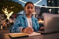 Trendy, creative and smart student studying online with a laptop late at night at a modern campus. Young, inspired and