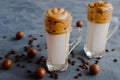 Trendy, trendy Dalgon coffee drink made from vegetable or regular milk with coffee foam. Two glasses stand on a black background