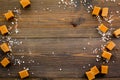 Trendy dessert. Salted caramel. Caramel cubes sprinkled by salt crystals on dark wooden background top view space for Royalty Free Stock Photo